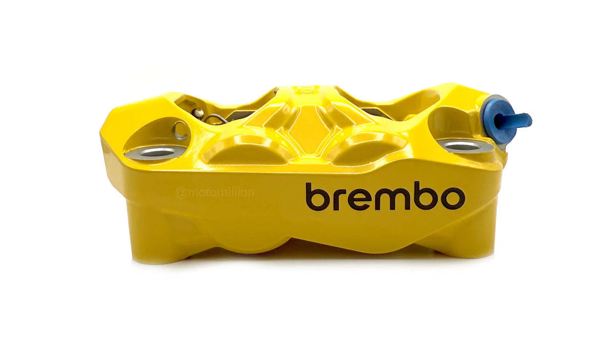 Yellow brake caliper with 'brembo' branding on a white background