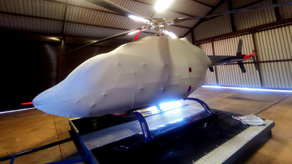 Helicopter on display inside a building with a metallic floor.