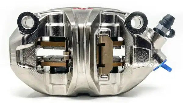 Brembo racing brake caliper on a white background